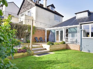 A backyard with lawn seating area wooden deck and house exterior at Highpoint Lodge in Lyme Regis