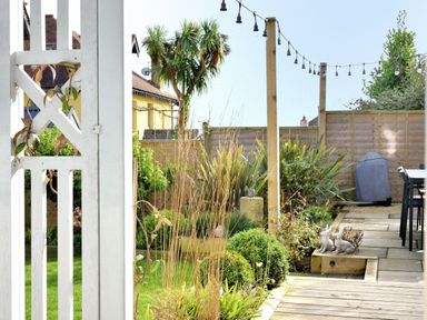 A garden with string lights wooden posts and patio furniture at Highpoint Lodge in Lyme Regis