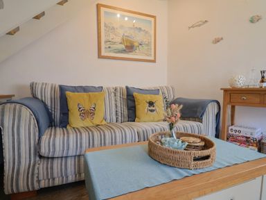 A living room with a couch and table at Cleve Cottage in Lyme Regis