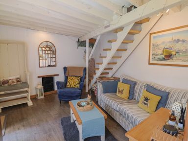 A living room with a sofa and chair at Cleve Cottage in Lyme Regis