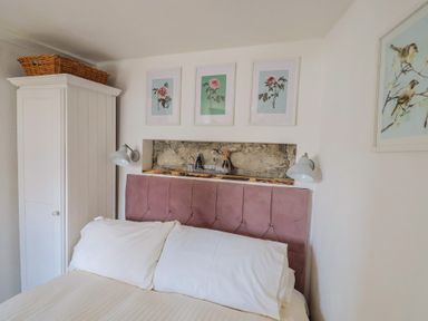 A bedroom with a bed and wardrobe at Cleve Cottage in Lyme Regis