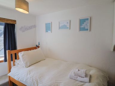 A bedroom with a bed and framed artwork at Cleve Cottage in Lyme Regis