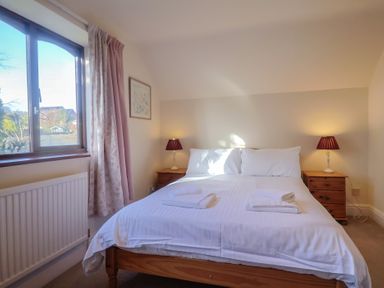 A bedroom with a bed and bedside tables at High Cliff Orchard in Lyme Regis