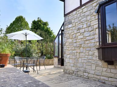 An outdoor patio area with a table and chairs at High Cliff Orchard in Lyme Regis