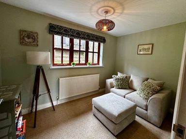 A snug with a sofa and lamp at 28 Barnes Meadow Uplyme