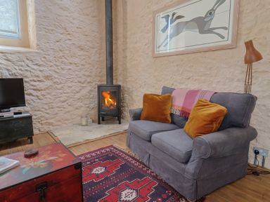 A living room with a sofa and fireplace at The Stone Barn in Bridport