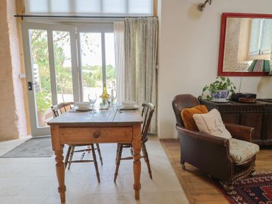 A dining room with a table and chairs at The Stone Barn in Bridport
