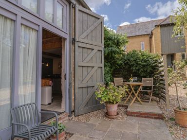 An outdoor seating area with a table and chairs at The Stone Barn in Bridport