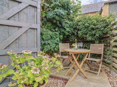 A garden with a table and chairs at The Stone Barn in Bridport