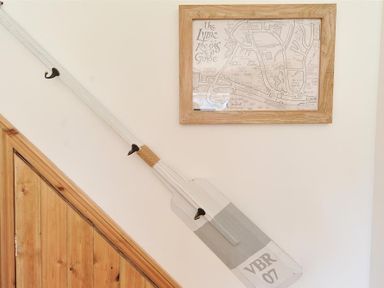 A wooden paddle hanging on a wall next to a framed map of Lyme Regis at Bethel Cottage in Lyme Regis