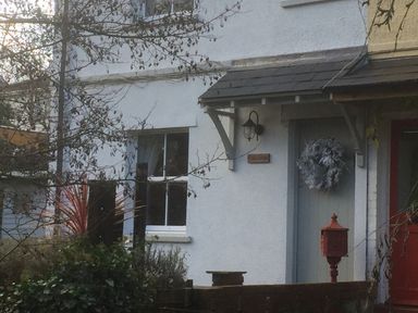 The exterior of a white house with a front door decorated with a wreath and a red mailbox at Bethel Cottage in Lyme Regis