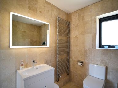 A bathroom with a sink cabinet mirror toilet and window at Harbour Heights Cottage Lyme Regis