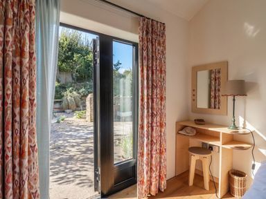 A bedroom with a desk and window open to outdoor at The Dairy in Bridport