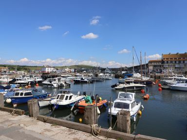 A harbor with boats and buildings at The Dairy in Bridport