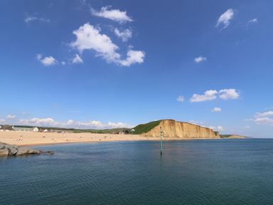 View of a beach with cliffs and water at The Dairy in Bridport