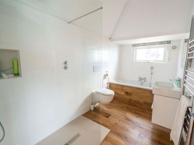 A bathroom with a walk in shower bath toilet and sink at 3 Beach Way House Lyme Regis