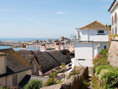 View of a coastal town with houses and a busy beach near the sea at 3 Beach Way House in Lyme Regis