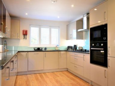 A kitchen with cabinets countertop stove oven microwave and window with blinds at Shire View in Lyme Regis