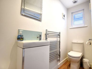 A bathroom with a toilet sink towel rack and a small window at Shire View in Lyme Regis