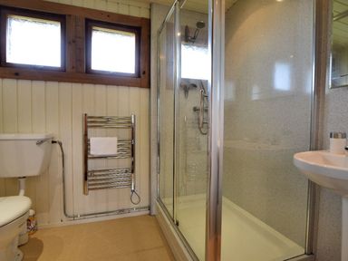 A bathroom with a toilet sink shower enclosure and towel rack at 10 Pinewood Retreat in Pinewood