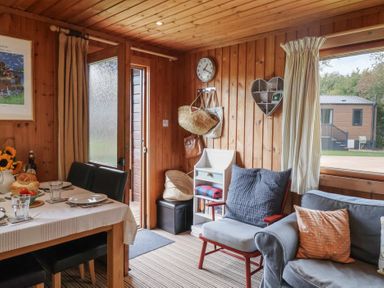 A living room with a dining table and chairs at 10 Pinewood Retreat in Pinewood