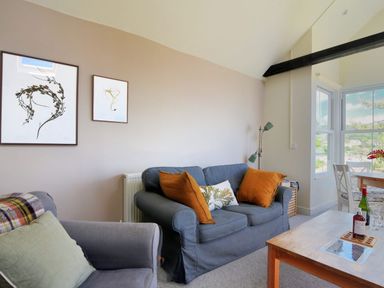 A living room with sofas and framed artwork on the wall at Bay View in Lyme Regis