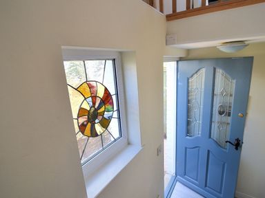 An entryway with a blue door and a window with a stained glass design at Bay View in Lyme Regis