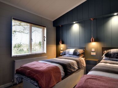 A bedroom with two single beds and a window with blinds at Hazelwood 4 @ Pinewood Retreat in Pinewood
