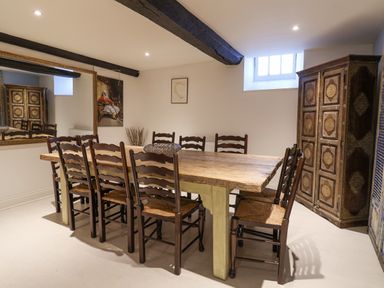 A dining room with a wooden table and eight chairs a large mirror and an ornate cabinet at Old Monmouth in Lyme Regis