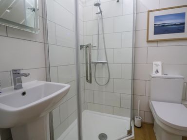 A bathroom with a sink a shower with glass door a toilet and a framed picture on the wall at Old Monmouth Lyme Regis