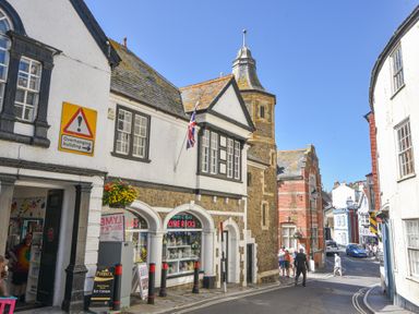 A street with shops and pedestrians near historic buildings at Old Monmouth in Lyme Regis