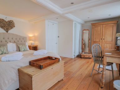 A bedroom with a bed and wooden furniture at The Little Rose in Lyme Regis