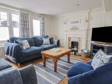 A living room with a sofa and television at The Little Rose in Lyme Regis