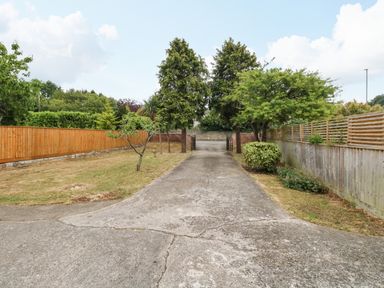 A driveway with trees and bushes on both sides at Sunny Haven in Preston