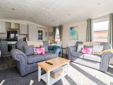 A living room with a sofa and dining table at Away Daze in Carnaby near Bridlington