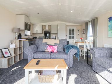 A living room with a sofa and dining area at Away Daze in Carnaby near Bridlington