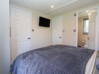 A bedroom with a bed and a television at Away Daze in Carnaby near Bridlington