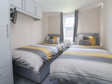 A bedroom with two single beds and a television at Away Daze in Carnaby near Bridlington