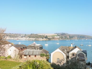 A waterfront view with buildings in the foreground and boats on a river at Port View in Falmouth