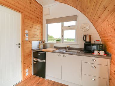 A small kitchen with a black mini fridge microwave kettle and sink at Primrose in Seaton near Hornsea