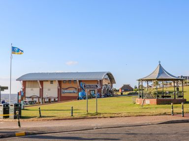 A seaside park area with a pavilion a building with a curved roof and a seaside award flag at Flat 1 in Hunstanton