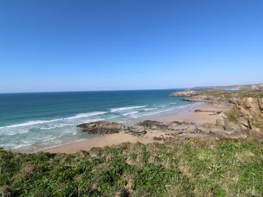 A coastal scene with beach waves rocks and grass at Dunes View in Cubert