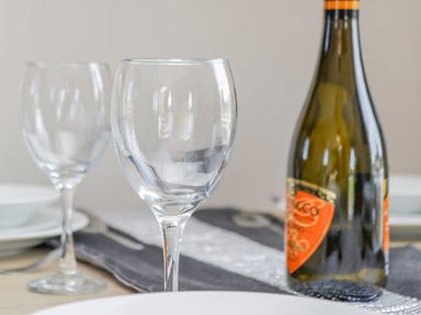 A table setting with empty wine glasses and a bottle with an orange label at Jeans Place in East Heslerton near West Heslerton