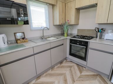 A kitchen with a sink microwave oven stove kettle and toaster at Jeans Place East Heslerton near West Heslerton
