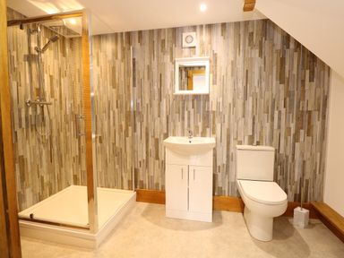 A bathroom with a shower cubicle sink with cabinet and toilet at Little Lodge in Pentney near Kings Lynn