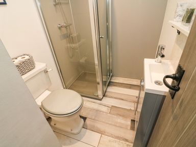 A small bathroom with a toilet sink and a glass shower at Herdie Hideaway in Appleby-In-Westmorland