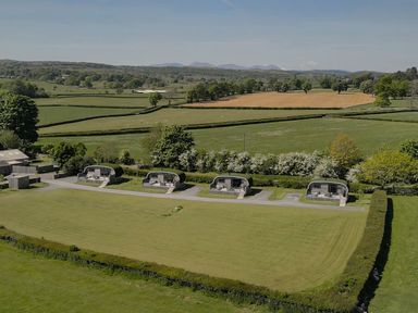 An outdoor area with huts and greenery at High Longlands in Cartmel