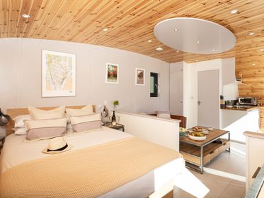 A bedroom with a bed a seating area a coffee table and a kitchenette at Little Heaning in Cartmel