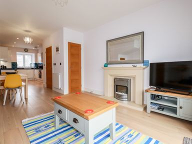 A living room with a coffee table rug fireplace and television at 6 Ocean Heights in Newquay