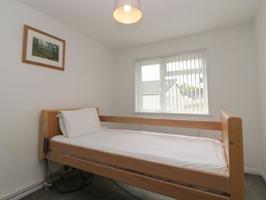 A bedroom with a single bed and a window with vertical blinds at Harcombe House Bungalow 11 in Chudleigh